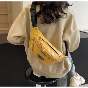 Nahaufnahme einer gelben PU-Leder-Brusttasche mit SUNIAN-Logo und schwarzem Gurt am Model