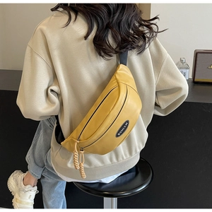 Detail der gelben Gürteltasche mit Sunian-Logo und beigen gewebten Reißverschlüssen
