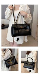 Detail view of black leather handbag featuring premium gold hardware and rotating metal clasp