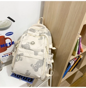 Detail of cream white printed backpack with cute bear patterns and side buckle strap