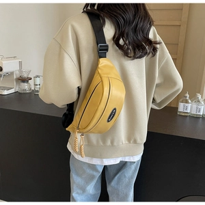 Rückansicht eines Models mit einer leuchtend gelben Umhängetasche in einem minimalistischen Café