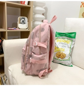 Side view of a pink printed backpack with cartoon graphics and adjustable side buckles