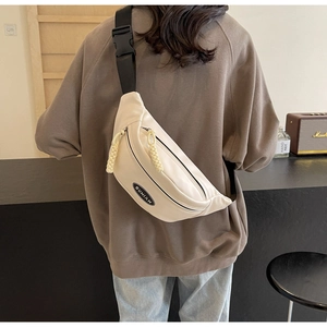 Detail der beige Umhängetasche mit SUNIAN Logo-Patch und gewebtem Kordelzug am Reißverschluss