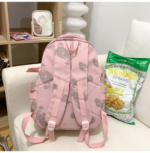 Detailed view of pink backpack with bear prints on a white sofa in a cozy room
