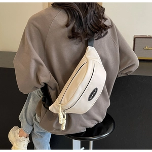 Detail der minimalistischen cremefarbenen Brusttasche mit Doppelreißverschluss