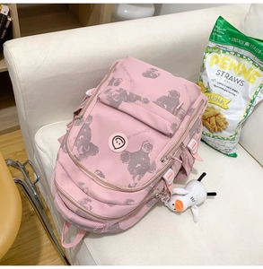 Detail view of pink backpack with bear prints, side buckles, and cute duck charm