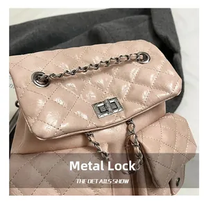 Close-up of pink quilted backpack showing the silver metal twist lock and chain detail