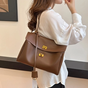 Deep brown leather handbag with gold metal buckles and crossbody strap for women