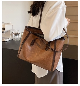 Brown vintage tote bag detail showing synthetic leather texture in a coffee shop setting