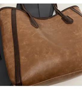 Close-up of vintage brown tote bag showing matte faux leather texture and stitching