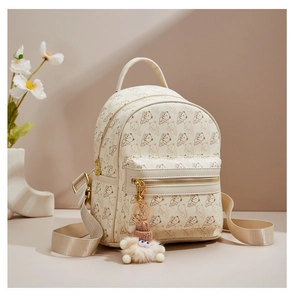 Detail of cream mini backpack with bear print, plush charm and front zipper pocket