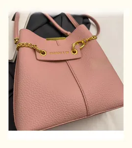Detail of pink lychee leather texture and golden chain on fashion bucket bag