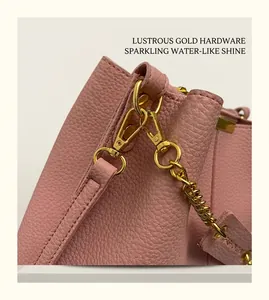 Detailed macro of premium gold hardware and lychee pattern leather on pink bucket bag
