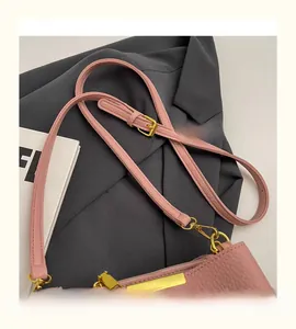 Detail of adjustable strap on pink leather bucket bag with gold metal hardware