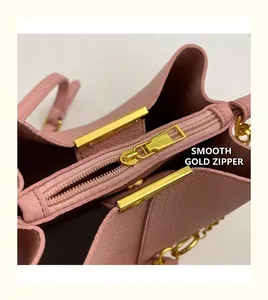 Close-up of pink litchi grain leather bucket bag with smooth gold metal zipper detail