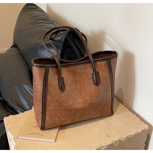 Detail of vintage brown tote bag texture on stone pedestal with rustic leather finish