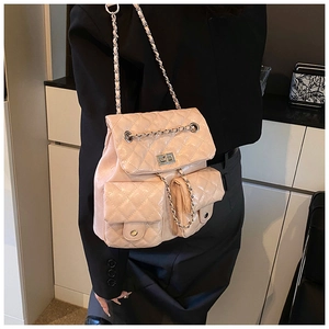 Rear view of a model wearing the quilted pink backpack with elegant chain straps