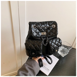 Close-up of black quilted mini backpack featuring silver twist lock and dual front pockets