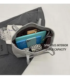 Vertical top view of large grey tote bag interior with multiple storage pockets and items