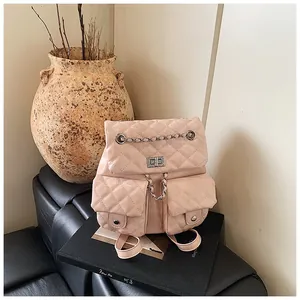 Detailed view of pink quilted leather backpack with silver metallic clasp and chain handle