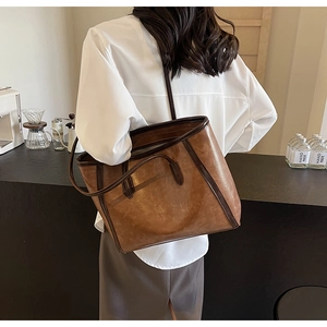 Detail of a large brown retro tote bag with dark trim, perfect for daily commute storage