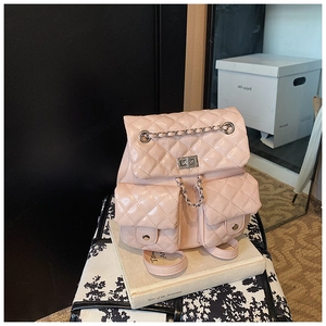 Detailed view of pink quilted leather backpack with silver chain and turn-lock closure