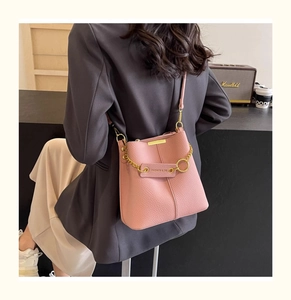 Detail view of pink bucket bag with lychee grain leather and gold chain accessory