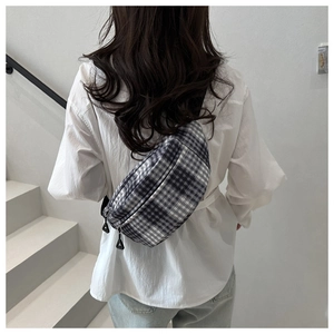 Detailed view of the checkered waist bag with adjustable strap on a casual outfit