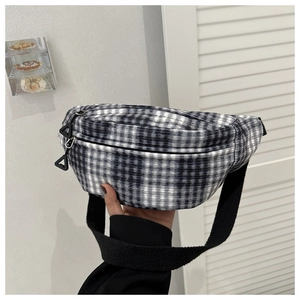 Detailansicht der schwarz-weißen Karogürteltasche mit Doppelreißverschluss und Gurt