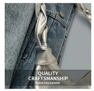 Close-up of silver metallic handbag with unique knotted braided handle texture