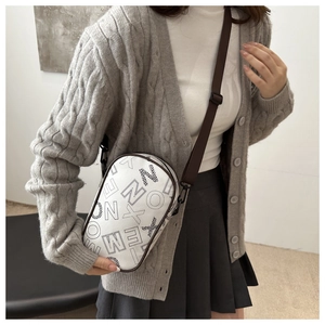 Detail of white crossbody bag with artistic letter prints and adjustable wide nylon strap