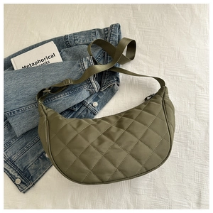 Detail of olive green quilted crescent bag featuring adjustable strap and nylon texture