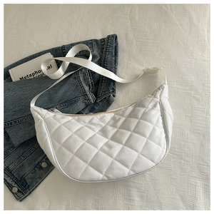 Detail of white quilted hobo bag with diamond stitching and adjustable woven strap