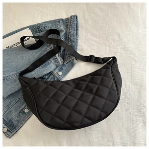 Detailed close-up of black quilted nylon crescent bag with adjustable wide strap