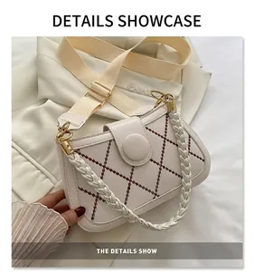 Detail der weißen gesteppten Ledertasche mit geflochtenem Griff und breitem Schultergurt