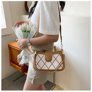 Detailansicht der Vintage-Stepptasche mit braunem Lederbesatz und modischem Web-Schultergurt