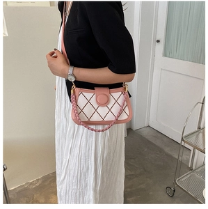 Rosa und cremefarbene Stepptasche mit gewebtem Gurt an einem Modell getragen
