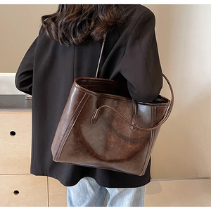 Deep brown vintage leather tote bag shown styled with a professional casual outfit