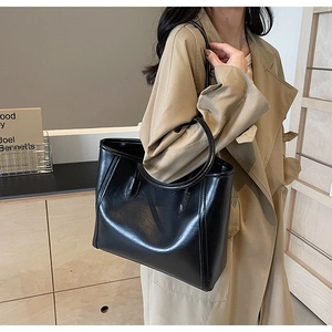 Detail of black large capacity tote bag in vintage oil wax leather with double handles
