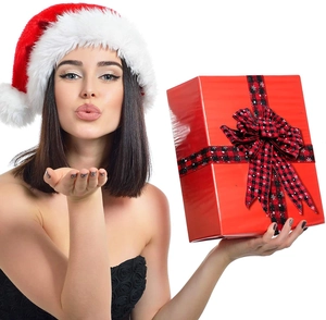 Woman in Santa hat holding red gift box decorated with red and black plaid snowflake ribbon