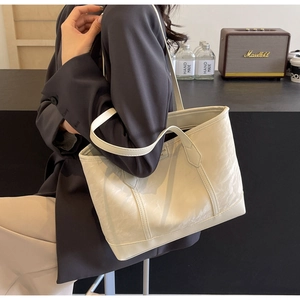 Chic cream tote bag with marble texture shown in a stylish cafe lifestyle setting