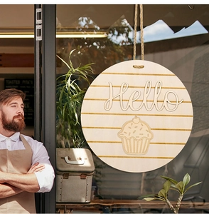 Close-up of a circular wooden door sign with Hello text and cupcake engraving