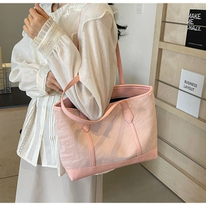 Detail of pink canvas tote bag showing ripple texture and leather trim on shoulder strap