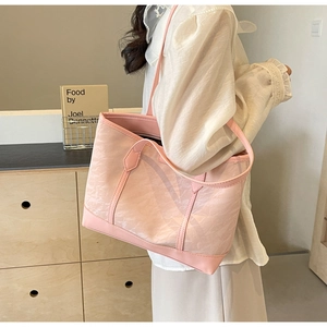 Close-up of pink tote bag showing textured fabric and versatile dual handle design