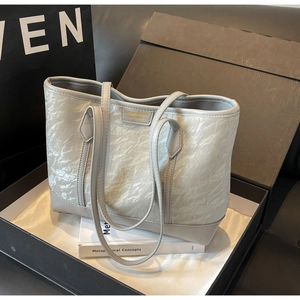 Close-up of marble texture tote bag inside a luxury gift box with golden logo detail