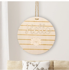 Macro detail of round wooden door sign with Hello carving and turkey motif on white wall