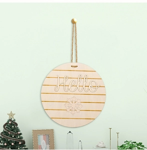 Detail view of round wooden door hanger with Hello text and festive snowflake patterns