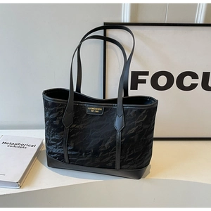 Detail showing the unique wrinkled texture and logo on this black tote shoulder bag