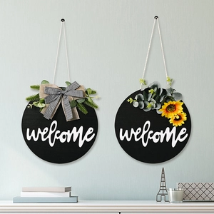 Detail of wooden welcome signs featuring sunflower, plaid bow, and greenery on blue wall