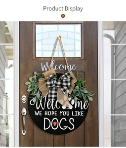 Detail of wooden welcome sign for dogs with burlap bow and artificial greenery decor